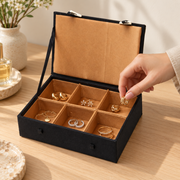 Schmuckkassette in Verwendung beim Herausnehmen eines Ohrrings – Gold, Klein.